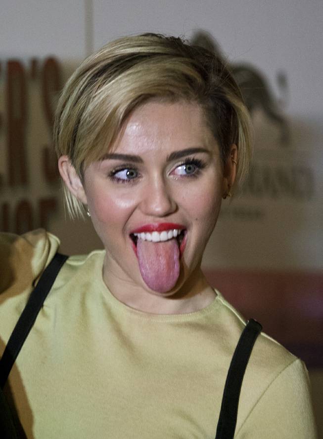 Miley Cyrus sticks her tongue out on the Red Carpet at the opening of Beacher's Madhouse MGM Grand Hotel & Casino on Friday, Dec. 27, 2013.