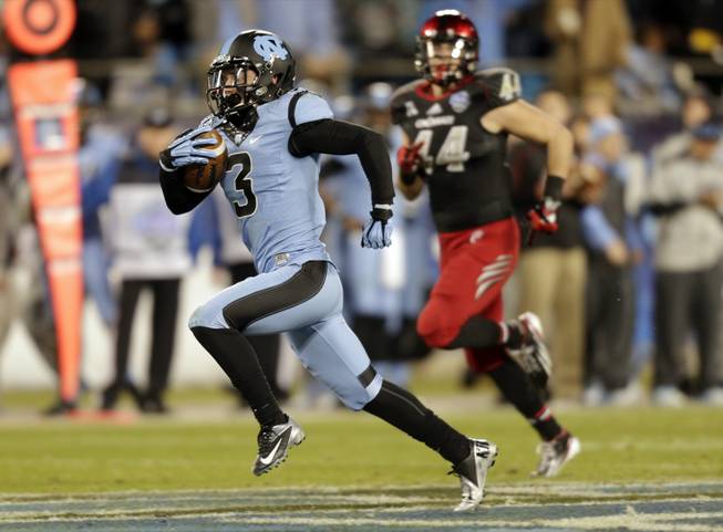 North Carolina's Ryan Switzer returns a punt for a touchdown past Cincinnati's Corey Mason during the second half of the Belk Bowl NCAA college football game in Charlotte, N.C., on Saturday, Dec. 28, 2013.