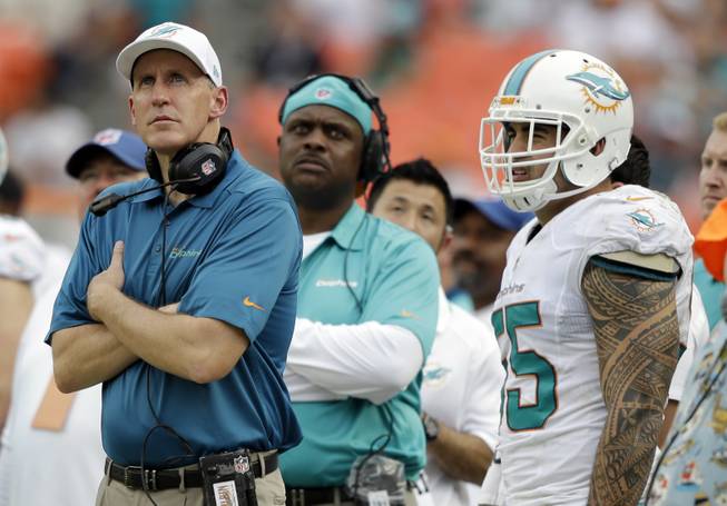 Miami Dolphins head coach Joe Philbin, left, and outside linebacker Koa Misi (55) watch in the final minutes of an NFL football game against the New York Jets, Sunday, Dec. 29, 2013, in Miami Gardens, Fla. The Jets defeated the Dolphins 20-7.