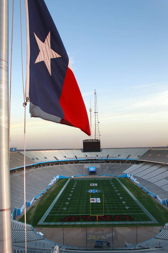 The flag of Texas flies over the field of the Cotton Bowl in Dallas which is painted Monday, Dec. 30, 2013, for UNLV to take on North Texas in Heart of Dallas Bowl on New Year's Day.