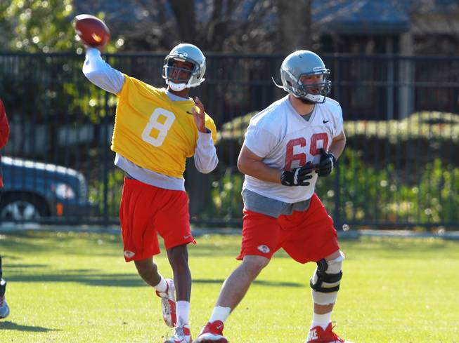 UNLV quarterback Caleb Herring throws a pass while lineman Brett Boyko sets up a block during UNLV's practice on the campus of Southern Methodist University for the Heart of Dallas Bowl Monday, Dec. 30, 2013 in Dallas.