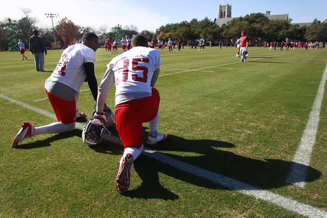UNLV wide receiver Devante Davis, left, and running back Tim Cornett take a knee during UNLV's practice on the campus of Southern Methodist University for the Heart of Dallas Bowl Monday, Dec. 30, 2013 in Dallas.