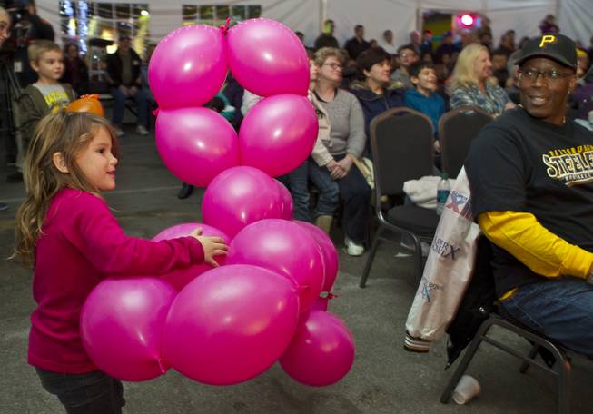 Aryan Moya, 4, carries off a giant balloon dog created by Tawney Bubbles during a family variety show in the Magical Forest at Opportunity Village on Monday , Dec. 30, 2013. L.E. Baskow