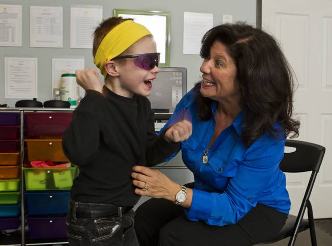 Dr. Susan DeVito readies Chase Black, 7, for some work at various stations within the Brain Balance Achievement Center on Monday, Dec. 30, 2013.