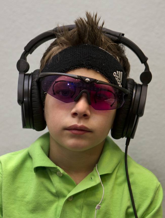 Christian Culotta, 9, wears high-tech glasses and headphones for visual and auditory stimulation at the Brain Balance Achievement Center on Monday, Dec. 30, 2013.