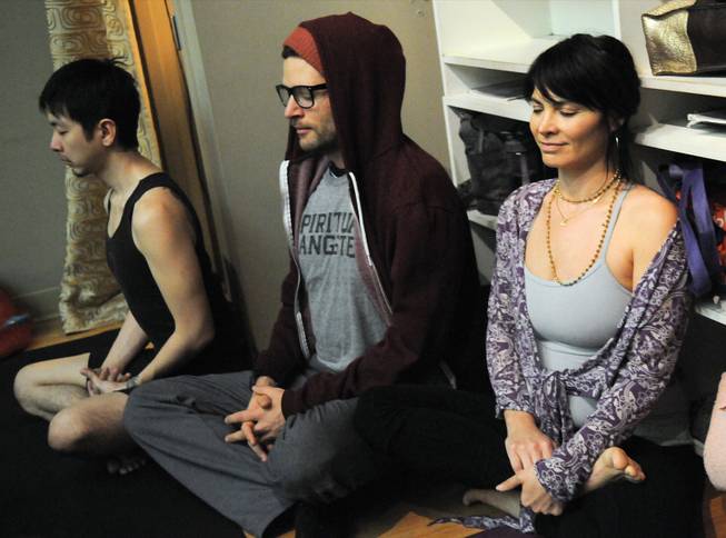 Jivamukti Yoga teacher Tomo Okabe, M.C. Yogi and his wife, Amanda Gia, participate in a Silent New Year’s Eve celebration at Jivamukti Yoga in New York on Tuesday, Dec. 31, 2012.