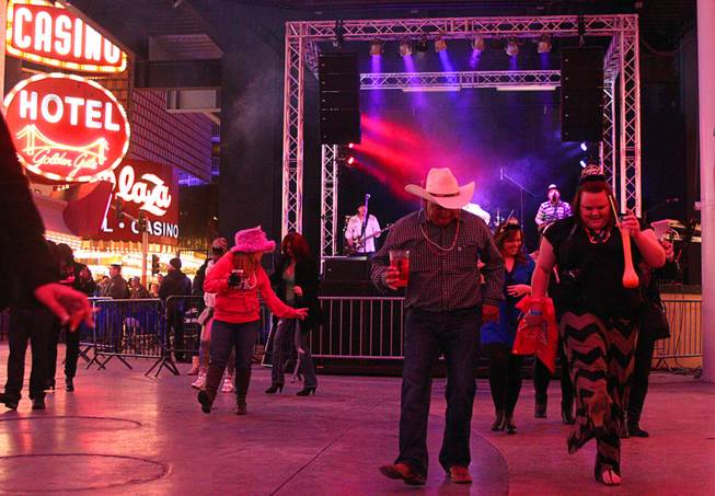 Partiers dance during New Year's Eve festivities at the Fremont Street Experience in downtown Las Vegas Tuesday, Dec. 31, 2013. An estimated 335,000 tourists were expected to visit Las Vegas to celebrate the new year.