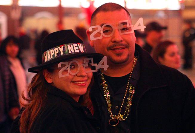 D'lynn Celis and Feliz Contreras of Phoenix pose during New Year's Eve festivities at the Fremont Street Experience in downtown Las Vegas Tuesday, Dec. 31, 2013. An estimated 335,000 tourists were expected to visit Las Vegas to celebrate the new year.