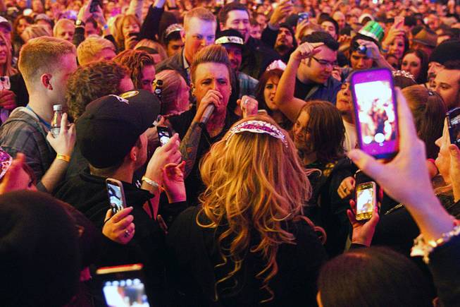 Coby, lead singer of Papa Roach, goes into the crowd during their set at the Fremont Street Experience in downtown Las Vegas, Tuesday Dec. 31, 2013. An estimated 335,000 tourists were expected to visit Las Vegas to celebrate the new year.