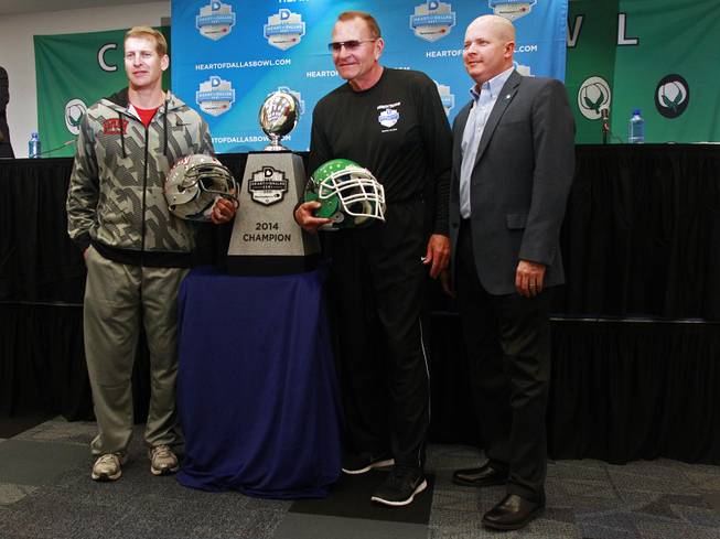 UNLV head coach Bobby Hauck, left, North Texas head coach Dan McCarney and Heart of Dallas Bowl executive Brant Ringler pose for photos during a news conference for the Heart of Dallas Bowl Tuesday, Dec. 31, 2013 at the Cotton Bowl in Dallas.