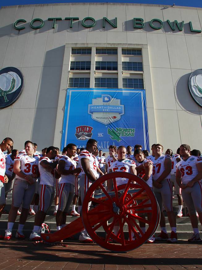 The UNLV football team gets ready to have their team photo taken with the Fremont Cannon for the Heart of Dallas Bowl Tuesday, Dec. 31, 2013 at the Cotton Bowl in Dallas.
