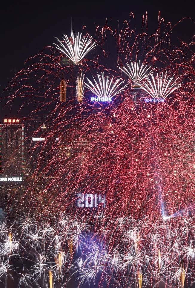 Fireworks explode at the Hong Kong Convention and Exhibition Centre over the Victoria Harbor during New Year's celebrations in Hong Kong, Wednesday, Jan. 1, 2014. 