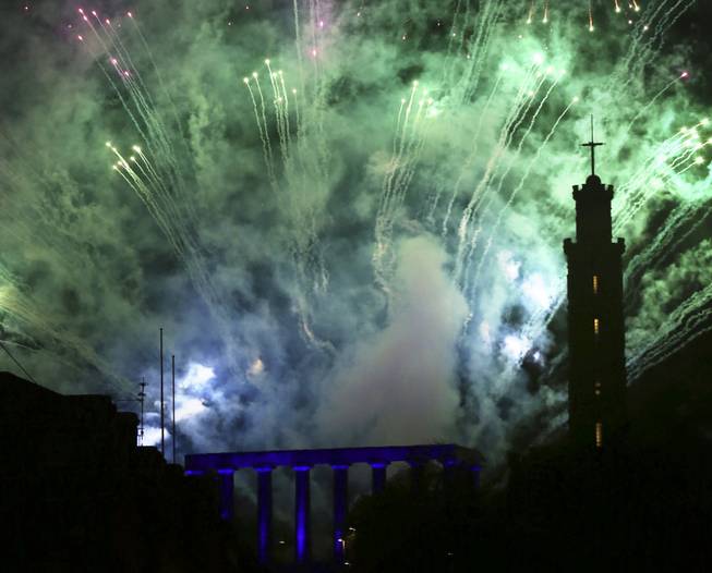 Fireworks illuminate the sky over Calton Hill, Edinburgh, Scotland, at the New Year's eve celebrations at Edinburgh Hogmanay (New Year) street party, Tuesday Dec. 31, 2013.  The celebrations this year are combined with marking the upcoming 2014 Commonwealth games. 