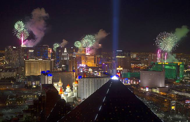 Fireworks fired from casino rooftops explode over the Las Vegas Strip just after midnight Jan. 1, 2014. An estimated 335,000 tourists were expected to visit Las Vegas for the New Year's festivities. Photo taken from the Mix nightclub at Mandalay Bay.