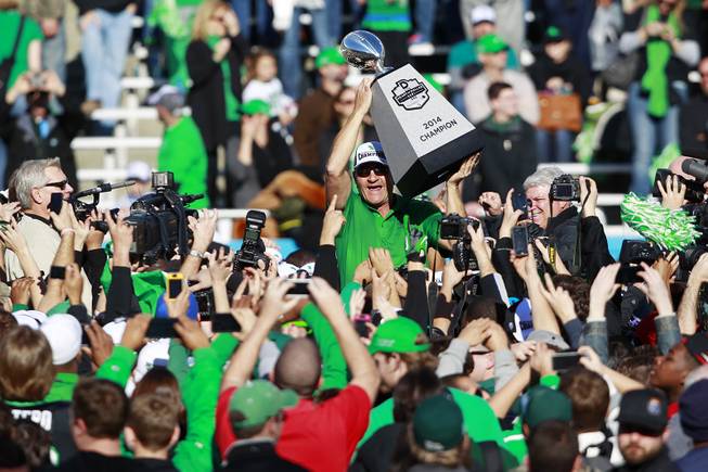 North Texas head coach Dan McCarney hoists the Heart of Dallas Bowl championship trophy after defeating UNLV 36-14 Wednesday, Jan. 1, 2014 at the Cotton Bowl in Dallas.