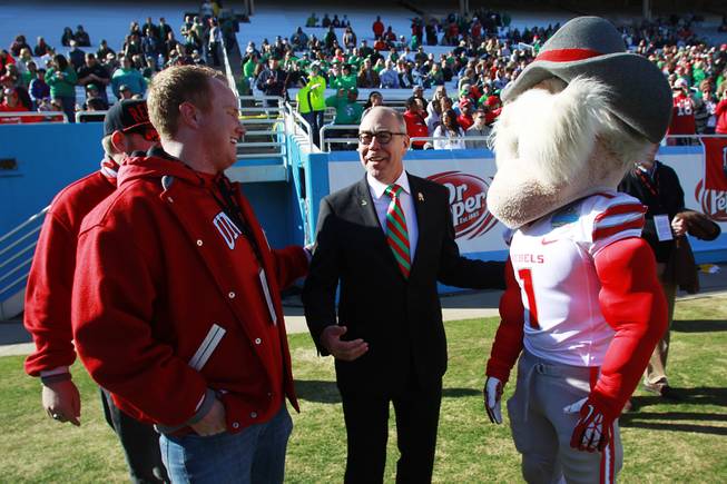 UNLV president Neal Smatresk tells Beau Brence, left, about when he met the person inside the Hey Reb suit, Jon "Jersey" Goldman before the Heart of Dallas Bowl against North Texas Wednesday, Jan. 1, 2014 at the Cotton Bowl in Dallas.