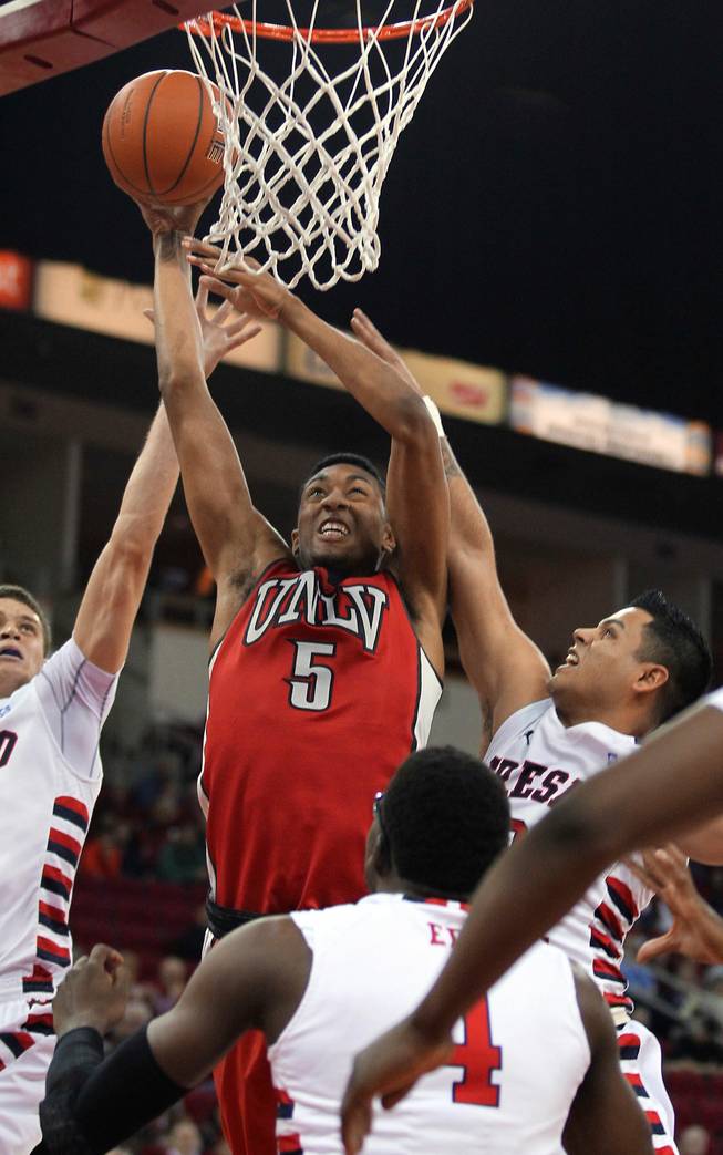 UNLV's Christian Wood goes in for a dunk as Fresno State's Tyler Johnson, left, and Cezar Guerrero defend during the first half of a NCAA college basketball game in Fresno, Calif., Wednesday, Jan. 1, 2014.