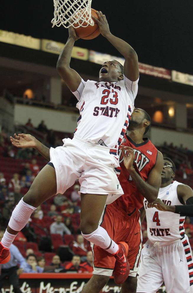 Fresno State's Marvelle Harris is fouled on his way to a lay-up by UNLV's Roscoe Smith in the second half of a NCAA college basketball game in Fresno, Calif., Wednesday, Jan. 1, 2014.