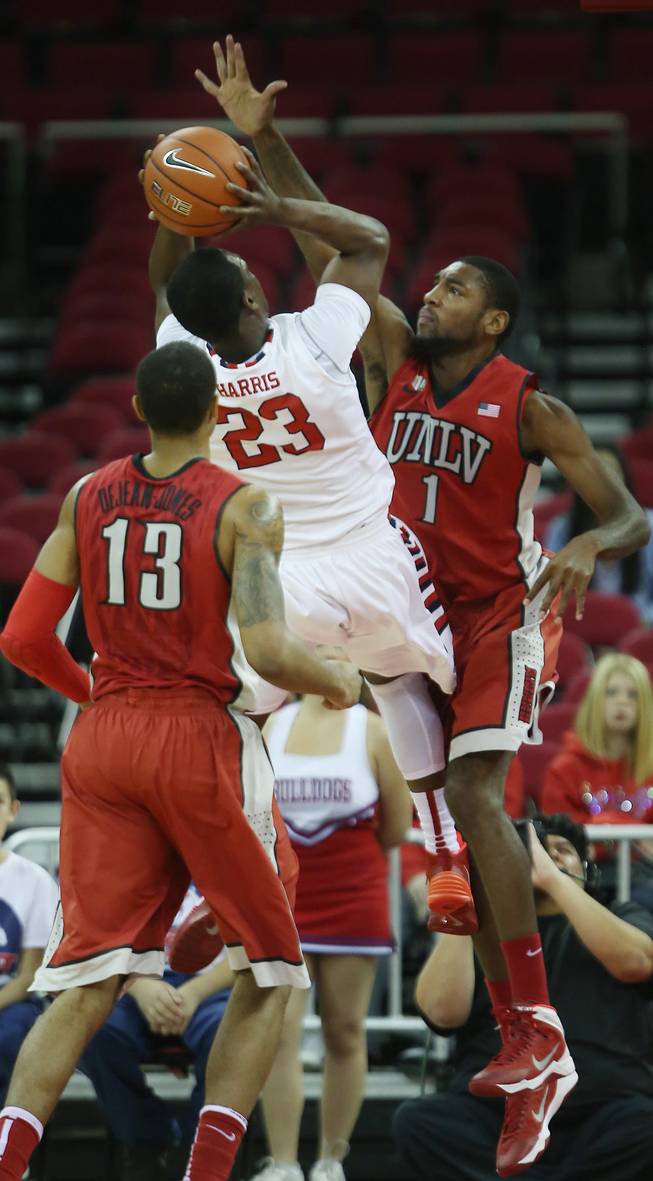 Fresno State's Marvelle Harris finds little room to shoot against UNLV's Roscoe Smith (1) in the first half of a NCAA college basketball game in Fresno, Calif., Wednesday, Jan. 1, 2014.