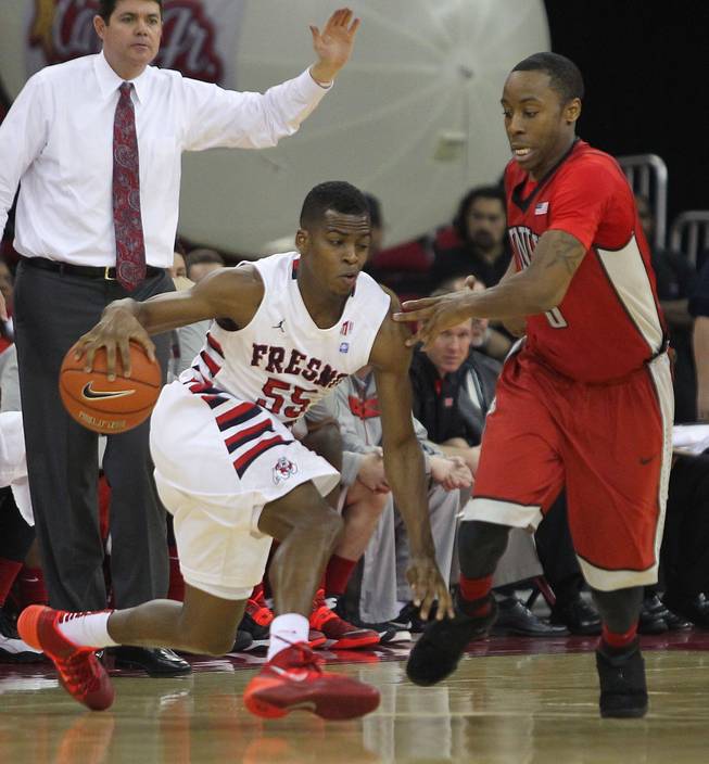 Fresno State's Allen Huddleston, left, dribbles the ball against UNLV's Kevin Olekaibe in the first half of a NCAA college basketball game in Fresno, Calif., Wednesday, Jan. 1, 2014.