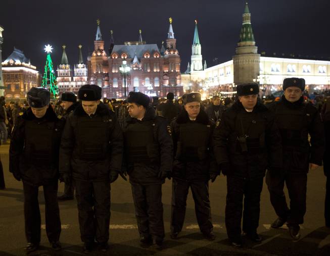 Russian police officers get ready to check people arriving at the Red Square ahead of the New Year's Eve festivities, in Moscow, Russia, Tuesday, Dec. 31, 2013. Russian authorities ordered police to beef up security at train stations and other facilities across the country after a suicide bomber killed 14 people on a bus Monday in the southern city of Volgograd. It was the second deadly attack in two days on the city that lies just 400 miles (650 kilometers) from the site of the 2014 Winter Olympics.