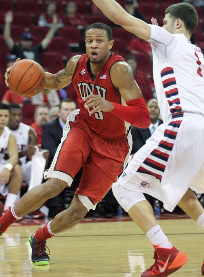 UNLV's Bryce Dejean-Jones, left, looks to drive around Fresno State's Tyler Johnson in the first half of a NCAA college basketball game in Fresno, Calif., Wednesday, Jan. 1, 2014.