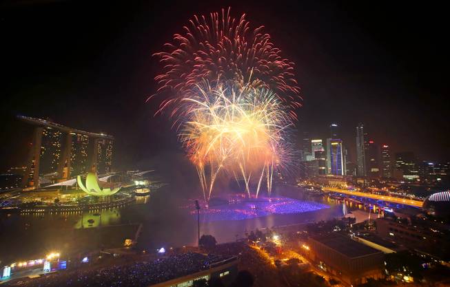 Fireworks explode over the financial district at midnight, Wednesday, Jan. 1, 2014 in Singapore. Celebrations started on New Year's Eve where concerts were held and thousands gathered on the streets to usher in the Year 2014.