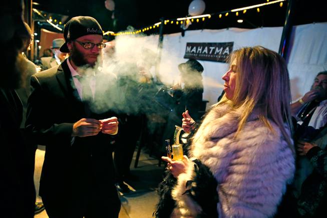Sheri Foster, of Denver, smokes marijuana during a Prohibition-era themed New Year's Eve party celebrating the start of retail pot sales, at a bar in Denver, late Tuesday Dec. 31, 2013. Colorado is to begin marijuana retail sales on Jan. 1, a day some are calling "Green Wednesday."