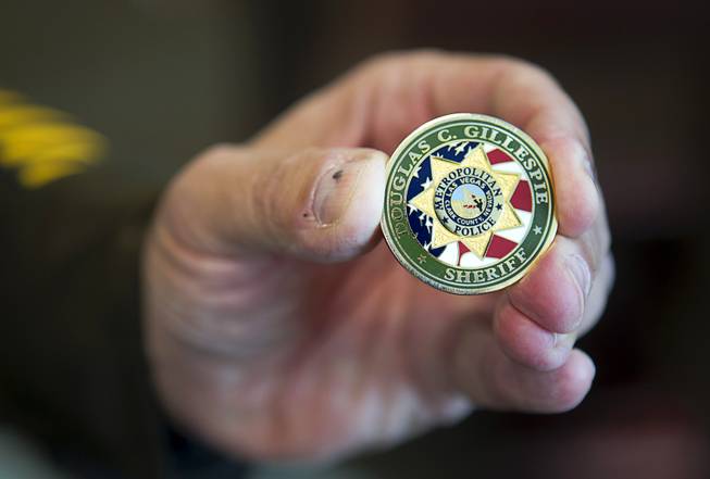 Sheriff Doug Gillespie holds a challenge coin during an interview at his office in Metro Police Headquarters Thursday, Jan. 2, 2014.