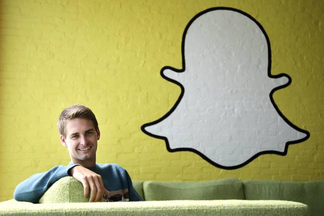 In this image from Thursday, Oct. 24, 2013, Snapchat CEO Evan Spiegel poses for photos in Los Angeles. Spiegel dropped out of Stanford University in 2012, three classes shy of graduation, to move back to his father's house and work on Snapchat. Spiegel’s fast-growing mobile app lets users send photos, videos and messages that disappear a few seconds after they are received.