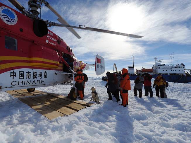 In this photo provided China's official Xinhnua News Agency, passengers from the trapped Russian vessel MV Akademik Shokalskiy, seen at right, prepare to board the Chinese helicopter Xueying 12 in the Antarctic Thursday, Jan. 2, 2014. 