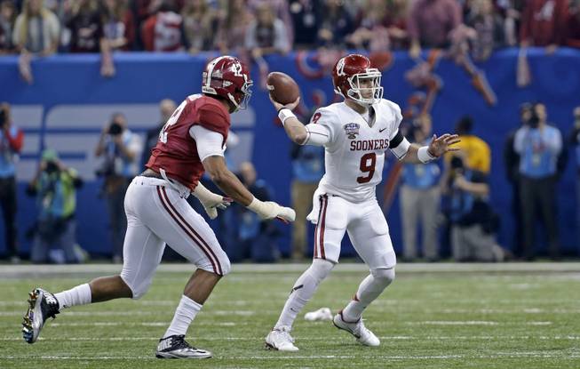 Oklahoma quarterback Trevor Knight (9) passes pas Alabama linebacker Adrian Hubbard (42) pursues in the first half of the NCAA college football Sugar Bowl against Alabama in New Orleans, Thursday, Jan. 2, 2014. 