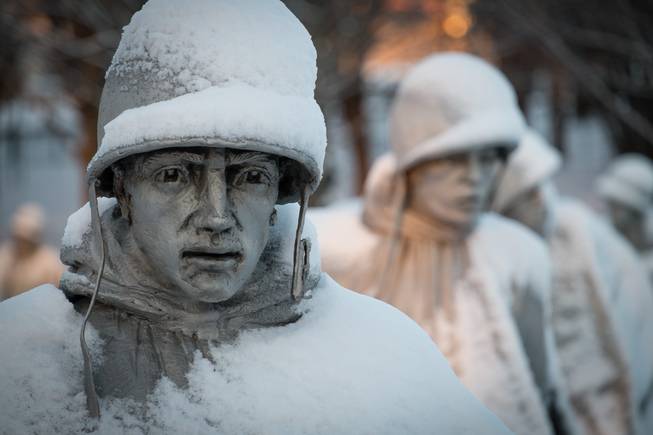 A light dusting of snow from an overnight storm covers the statutes at the Korean War Memorial in Washington early Friday morning Jan. 3, 2014. After a storm blew through the Washington region overnight, roads are being cleared and many schools systems are closed. The federal government and the District of Columbia government will be open Friday, but workers have the option to take leave or telework. (AP Photo/J. David Ake)