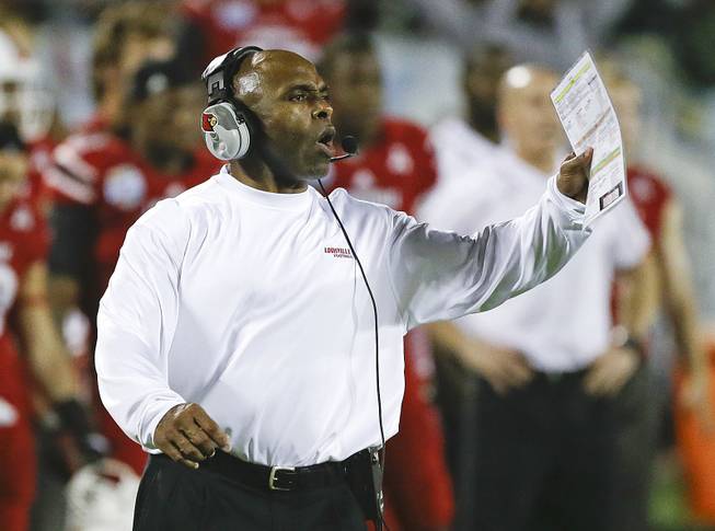 Louisville coach Charlie Strong calls out to players on the field during the second half of the Russell Athletic Bowl NCAA college football game against Miami in Orlando, Fla., Saturday, Dec. 28, 2013. 