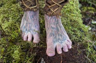 Mick Dodge's feet are tattooed with the images of roots. He stands on some moss at his cabin along the Sol Duc River near Forks, Wash., on January 3, 2014. Dodge is the subject of 