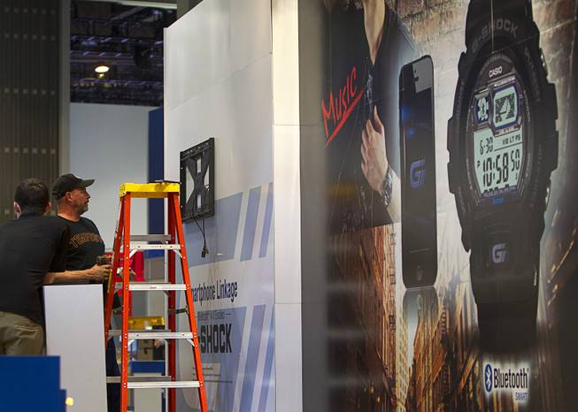 Workers set up a display at a Casio booth in preparation for the 2014 Consumer Electronics Show (CES) at the Las Vegas Convention Center Saturday, Jan. 4, 2014.