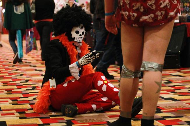 Jacob van Patten sits on the ground while looking at his phone at Otakon Vegas on Saturday, Jan. 4, 2014, at Planet Hollywood.