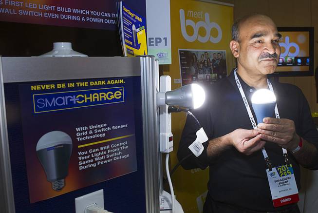 Founder Shailendra Suman poses with a SmartCharge LED lightbulb during "CES Unveiled," a media preview event to the annual Consumer Electronics Show (CES), in Las Vegas, Jan. 5, 2014. The bulb, which retails for $25.00, has a rechargeable battery and will give about four hours of light is the power goes out, Suman said.