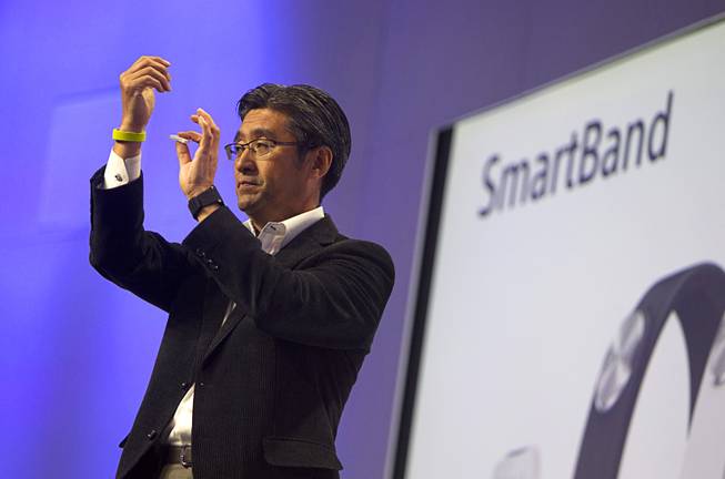 Kunimasa Suzuki, president/CEO of Sony Mobile Communications, displays a Sony SmartBand (L) and Core during a Sony news conference at the International Consumer Electronics Show (CES), in Las Vegas, Monday Jan. 6, 2014. The Core wearable device will be able to record data about your activities and movement and display the information in a LifeLog app.