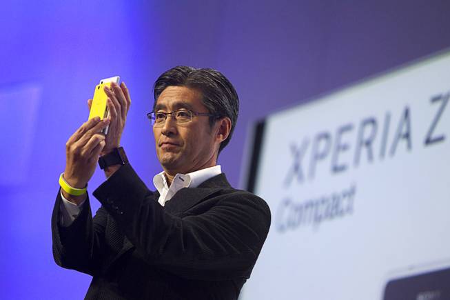 Kunimasa Suzuki, president/CEO of Sony Mobile Communications,  compares the size of an Experia Z1 Smartphone with a new smaller Xperia Z1 Compact during a Sony news conference at the International Consumer Electronics Show (CES), in Las Vegas, Monday Jan. 6, 2014.