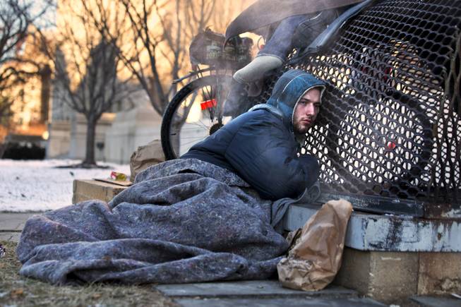 Nick warms himself on a steam grate with three other homeless men by the Federal Trade Commission, just blocks from the Capitol, during frigid temperatures in Washington, Saturday, Jan. 4, 2014. A winter storm that swept across the Midwest this week blew through the Northeast on Friday, leaving bone-chilling cold in its wake.