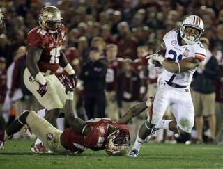 Auburn's Tre Mason (21) gets past Florida State's Telvin Smith during the second half of the NCAA BCS National Championship college football game Monday, Jan. 6, 2014, in Pasadena, Calif. 