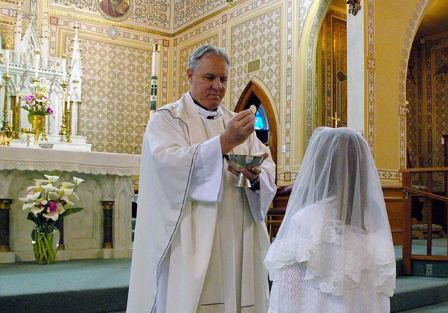 This May 2012 file photo shows the Rev. Eric Freed giving First Communion in St. Bernard Catholic Church in Eureka, Calif. 