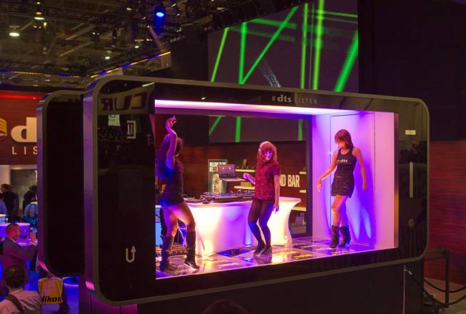 Dancers and a DJ perform in a stage shaped like a giant smarphone at the DTS booth during the 2014 International Consumer Electronics Show (CES) in Las Vegas, Tuesday Jan. 7, 2014.