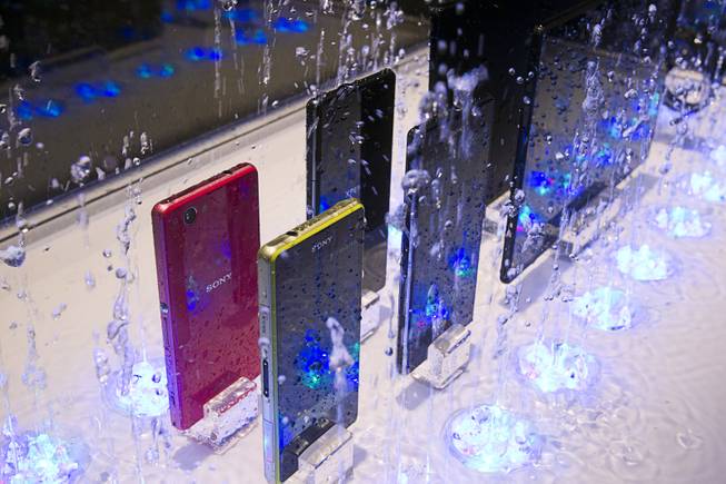 Water splashes around a display of waterproof Sony smartphones and tablets during the 2014 International Consumer Electronics Show (CES) in Las Vegas, Tuesday Jan. 7, 2014.