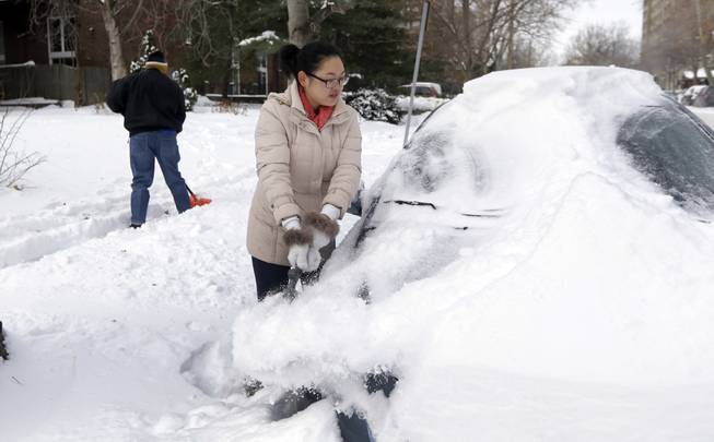 Cecy Wang, right, clears snow off her car as Samuel Scott, left, shovels a sidewalk Tuesday, Jan. 7, 2014, in St. Louis. As Missourians muddled through another frigid day Tuesday, the worst cold snap in nearly two decades was about to come to an end but many roads remained partly snow-covered two days after a winter storm dumped several inches of snow.