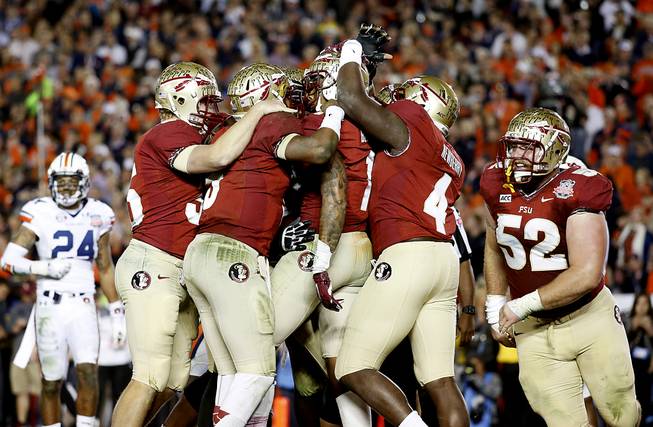 Florida State wide receiver Kelvin Benjamin (1) is surrounded by teammates after scoring the game-winning touchown against Auburn University in the 2014 BCS Championship NCAA College Football game on Monday, Jan. 6, 2014 in Pasadena, Calif. Florida State defeated Auburn 34-31.