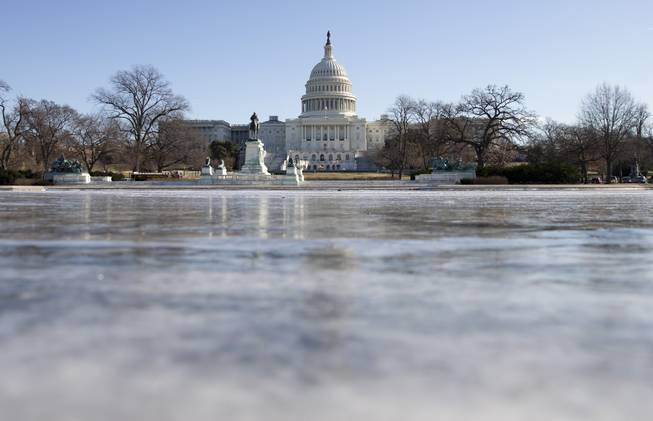 The reflecting pool in front of the U.S. Capitol building is frozen over, Tuesday, Jan. 7, 2014, in Washington. 