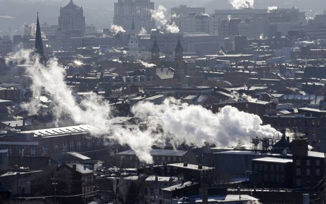 Steam rises from buildings Tuesday, Jan. 7, 2014, in downtown Cincinnati where temperatures were below zero in the morning.  Brutal, life-threatening cold descended over the East and the South, sending the mercury plummeting Tuesday into the single digits and teens.