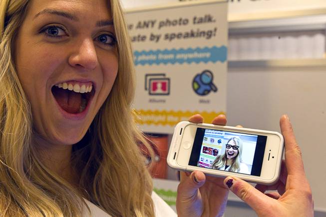 Gillian Pennington holds a smartphone with a animated, speaking image of herself in the Freak 'n Genius booth during the 2014 International Consumer Electronics Show (CES) in Las Vegas, Jan. 8, 2014. Using the YAKiT app, free download for iOS, a user can easily add talking animation to any photo.